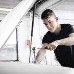 A young mechanic working at a white car
